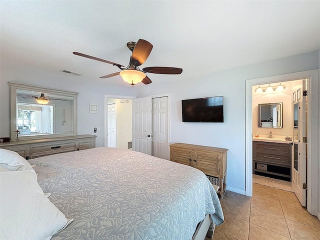 12817 2nd Isle, Hudson, FL 34667 - bedroom featuring light tile patterned floors, a closet, ceiling fan, and connected bathroom