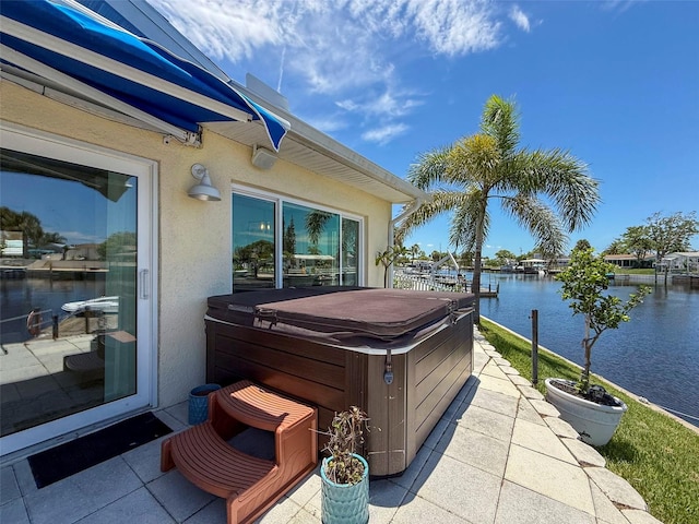 12817 2nd Isle, Hudson, FL 34667 - view of patio with a hot tub and a water view