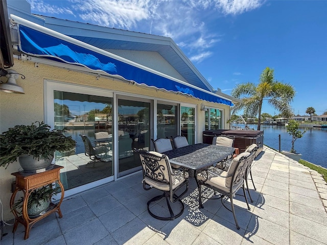 12817 2nd Isle, Hudson, FL 34667 - view of patio / terrace with a hot tub, a water view, and outdoor dining space
