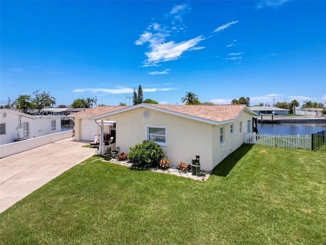 12817 2nd Isle, Hudson, FL 34667 - view of front facade with stucco siding, driveway, a garage, and a water view