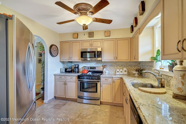 38 Sweet Gum Rd, Howell, NJ 07731 - kitchen featuring stainless steel appliances, decorative backsplash, a ceiling fan, arched walkways, and light brown cabinetry