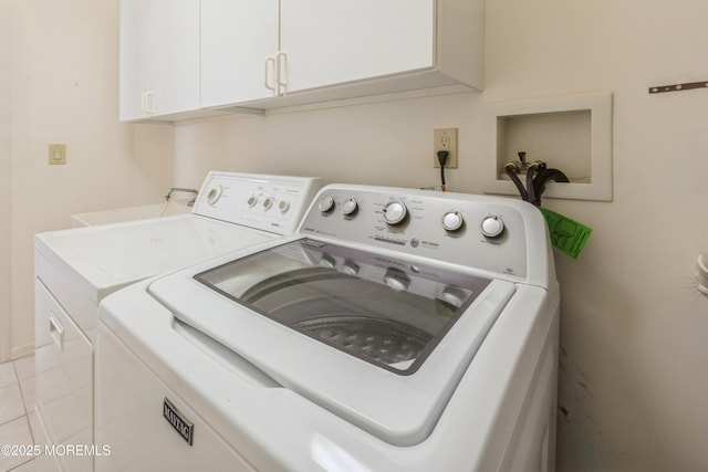 clothes washing area featuring cabinet space and washing machine and clothes dryer