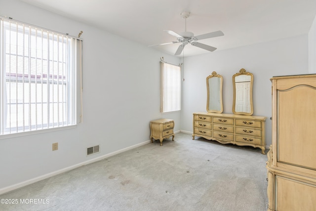 unfurnished bedroom featuring a ceiling fan, carpet, visible vents, and baseboards