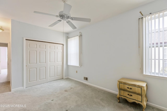 unfurnished bedroom with ceiling fan, carpet flooring, visible vents, baseboards, and a closet