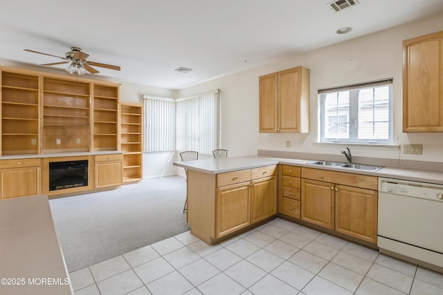 kitchen featuring white dishwasher, light carpet, a peninsula, a sink, and visible vents