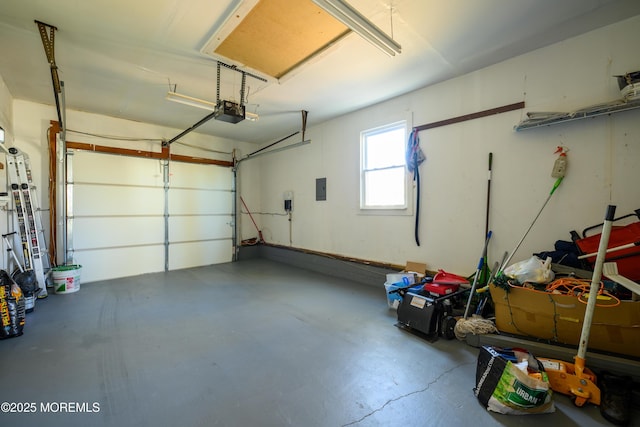 garage with a garage door opener and electric panel