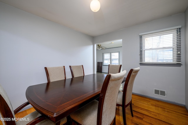 dining space with wood-type flooring