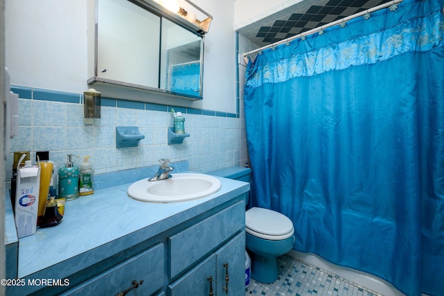 bathroom with tile walls, tile patterned flooring, vanity, curtained shower, and toilet