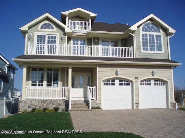 view of front of house with a balcony, a porch, and a garage