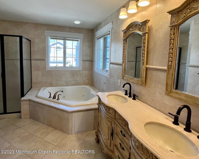 bathroom featuring tile walls, tile floors, double sink vanity, and plus walk in shower