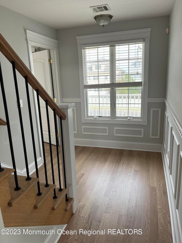 stairway with light hardwood / wood-style flooring