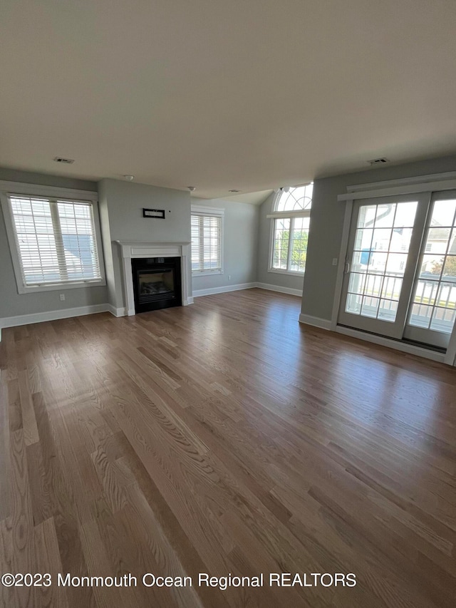 unfurnished living room with dark hardwood / wood-style flooring