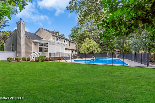 view of swimming pool with fence private yard, a yard, a wooden deck, a fenced in pool, and a pergola