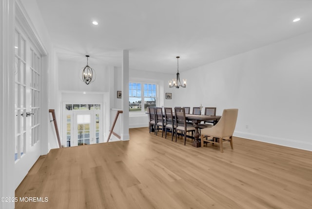 dining area featuring light hardwood / wood-style flooring and a notable chandelier