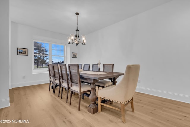 dining space with a chandelier and light wood-type flooring