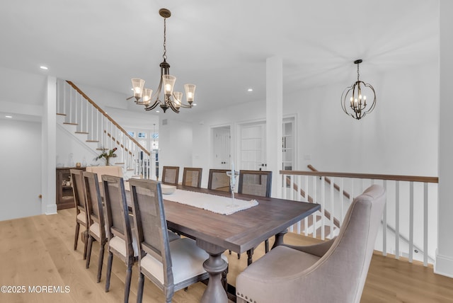 dining space featuring light hardwood / wood-style floors and an inviting chandelier