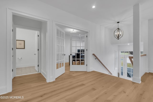 interior space with a chandelier, french doors, and light hardwood / wood-style floors