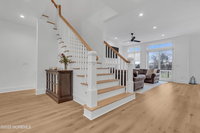 stairway with hardwood / wood-style flooring and ceiling fan