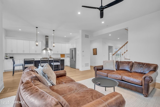 living room featuring ceiling fan and light hardwood / wood-style flooring