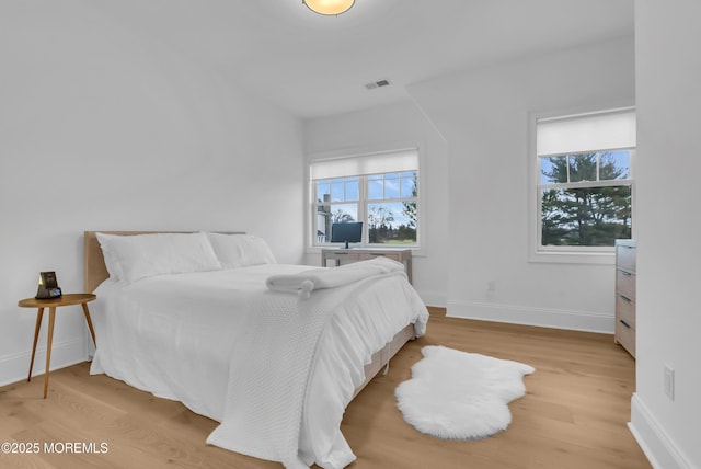 bedroom featuring wood-type flooring and multiple windows