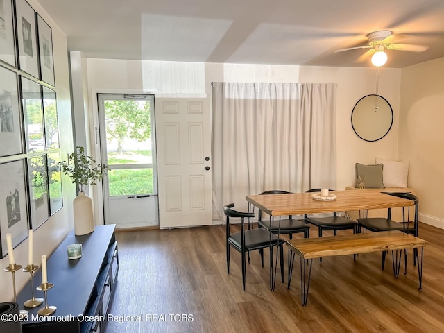 dining space with baseboards and wood finished floors