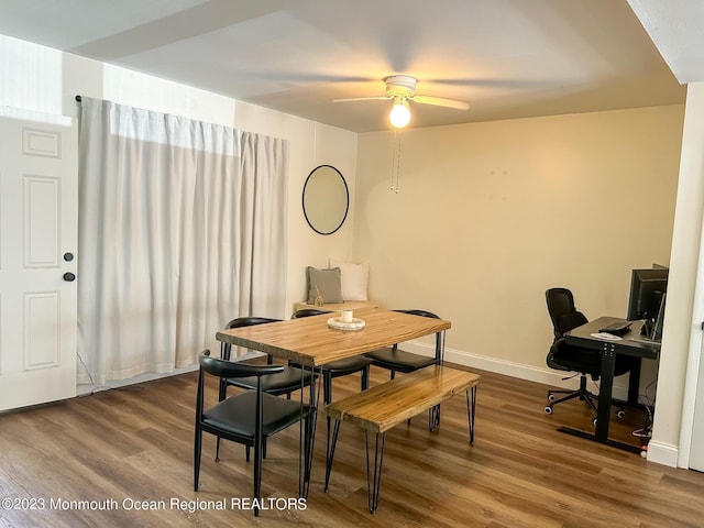 dining area with a ceiling fan, baseboards, and wood finished floors