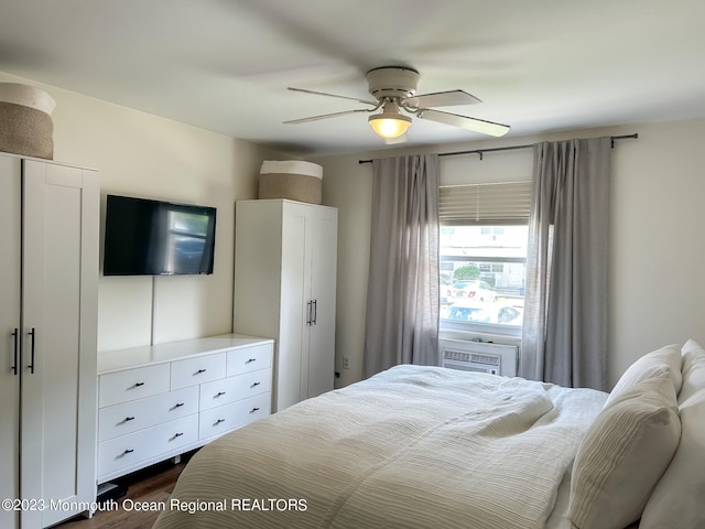 bedroom featuring cooling unit, a ceiling fan, and dark wood-style flooring