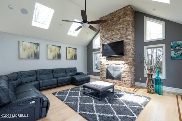 living room featuring ceiling fan, high vaulted ceiling, a fireplace, and hardwood / wood-style floors