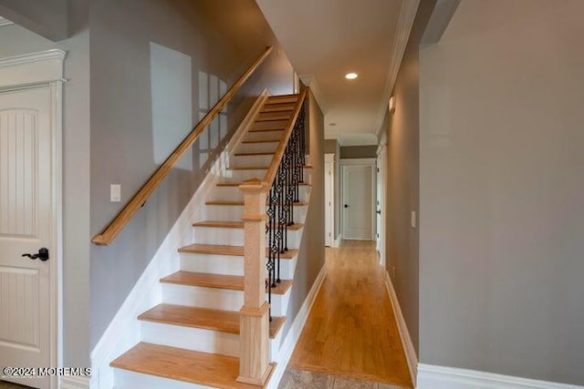 stairway featuring crown molding and hardwood / wood-style floors