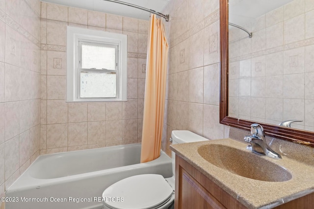 full bathroom with toilet, shower / tub combo with curtain, vanity, and tile walls