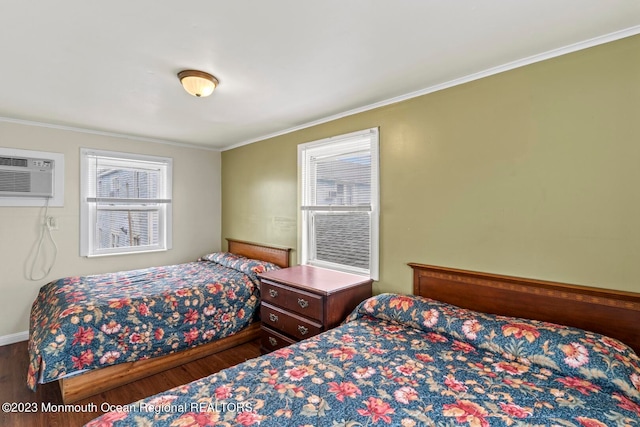 bedroom with crown molding, dark wood-type flooring, and a wall mounted air conditioner