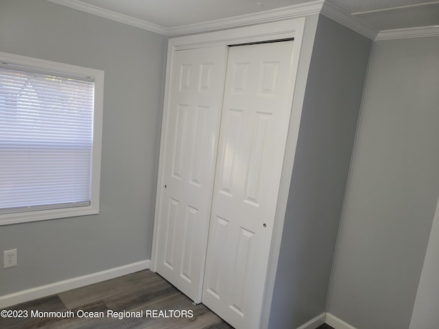 unfurnished bedroom featuring ornamental molding, dark hardwood / wood-style floors, and a closet