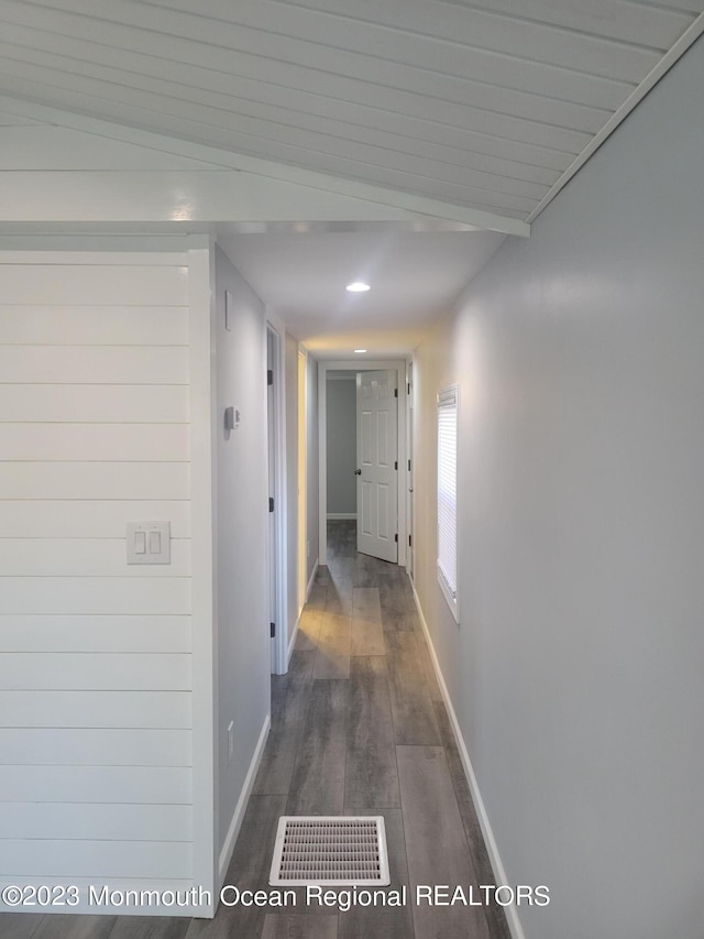 corridor featuring lofted ceiling and dark wood-type flooring