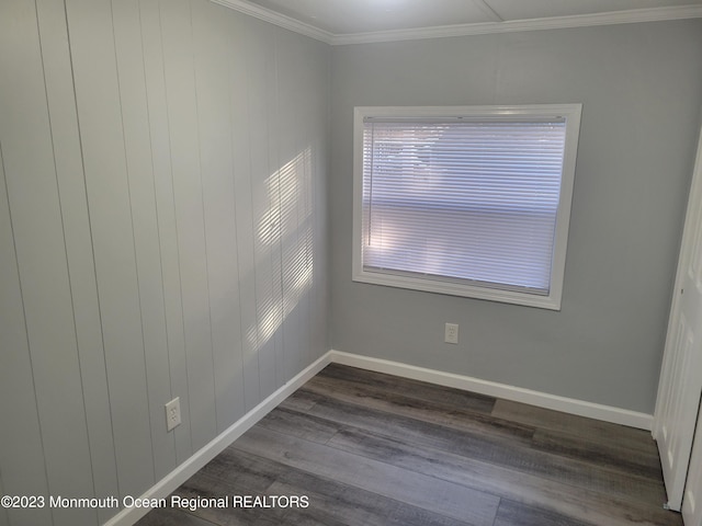 spare room with dark hardwood / wood-style floors and crown molding