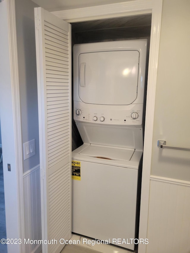 clothes washing area with stacked washer and clothes dryer