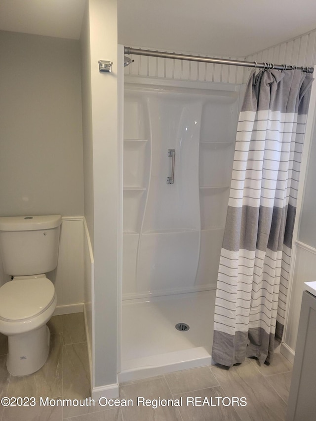 bathroom featuring tile floors, toilet, vanity, and curtained shower