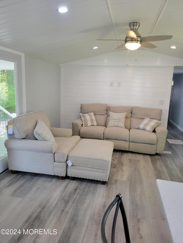 living room featuring hardwood / wood-style flooring, ceiling fan, and vaulted ceiling