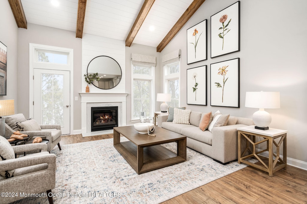 living room with vaulted ceiling with beams and light wood-type flooring