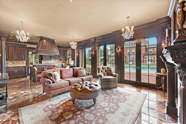 living room featuring an inviting chandelier, crown molding, and french doors