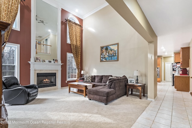 living room featuring light tile floors, crown molding, and a towering ceiling