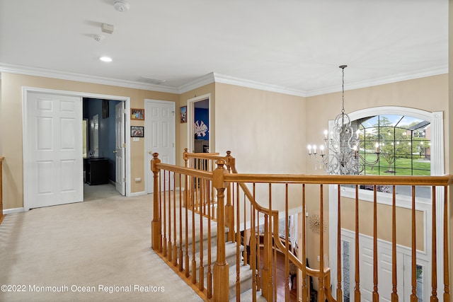 hallway featuring an inviting chandelier, ornamental molding, and light carpet