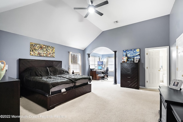 bedroom featuring ceiling fan, ensuite bath, light colored carpet, and high vaulted ceiling