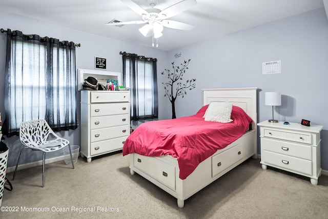 carpeted bedroom with multiple windows and ceiling fan