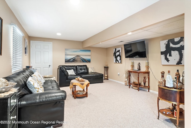 carpeted living room with a drop ceiling