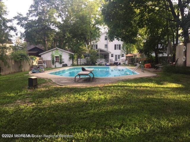 view of swimming pool with a yard