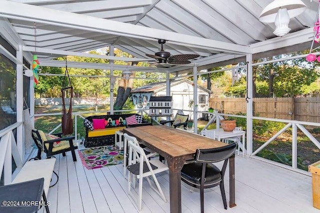 sunroom featuring vaulted ceiling with beams and ceiling fan