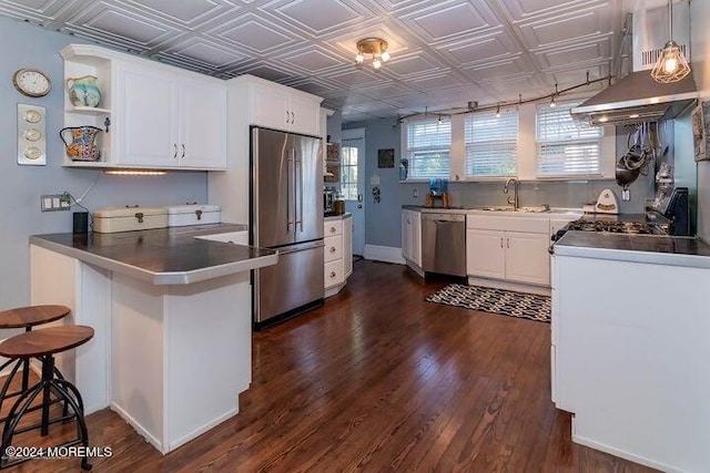 kitchen featuring decorative light fixtures, white cabinetry, sink, and stainless steel appliances