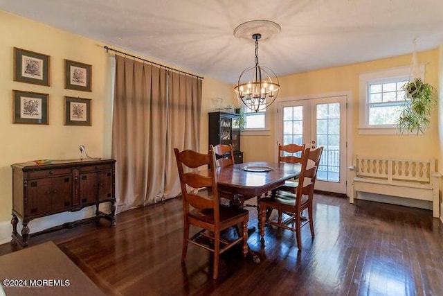 dining space featuring dark hardwood / wood-style floors, french doors, and an inviting chandelier