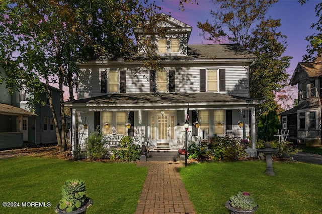 view of front of property with a porch and a lawn