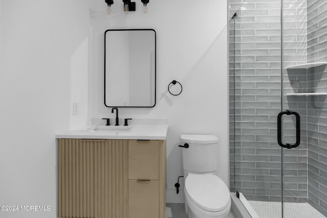 bathroom with toilet, a shower with door, and vanity